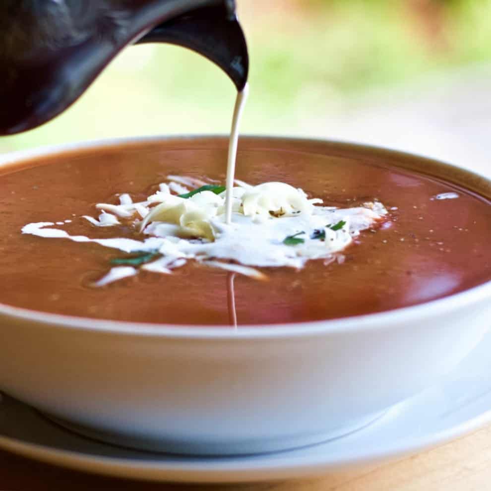 Roasted Pepper Tomato Soup With Cream Poured In.