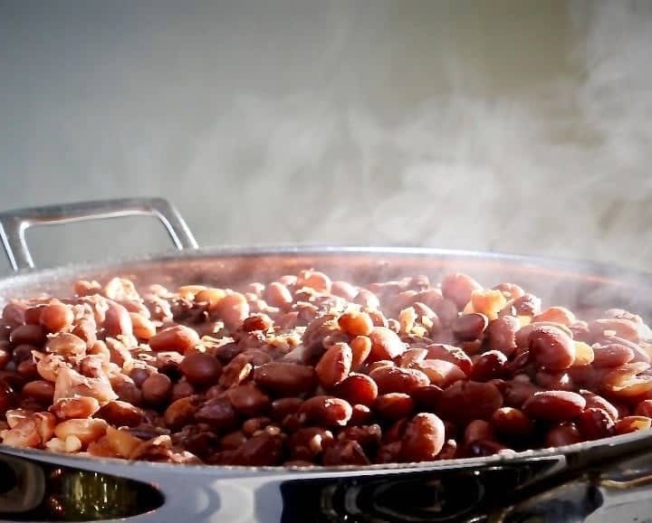 Making Homemade Refried Beans in a skillet. Refrying cooked pinto beans is a VERY frugal way to add delicious flavor to your Mexican meals. Add your own touches and use your Instant Pot to make this whole process a snap! Read more on Homemade Food Junkie! #refriedbeansrecipes #beanrecipes #mexicancooking #mexicancuisine #mexicanrecipes