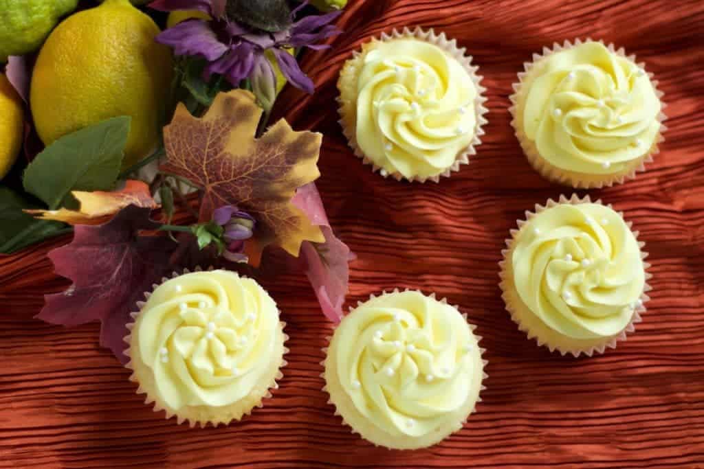 Lemony Lemon Cupcakes On A Burnt Orange Shiny Fabric With Lemons And Fall Leaves. 