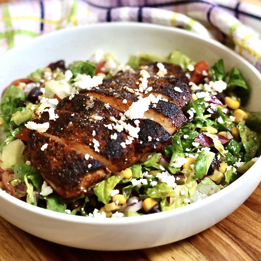Blackened Chicken Salad with Corn and Black Beans 2 blackened chicken salad with corns and beans in a white serving size bowl chicken arranged on top