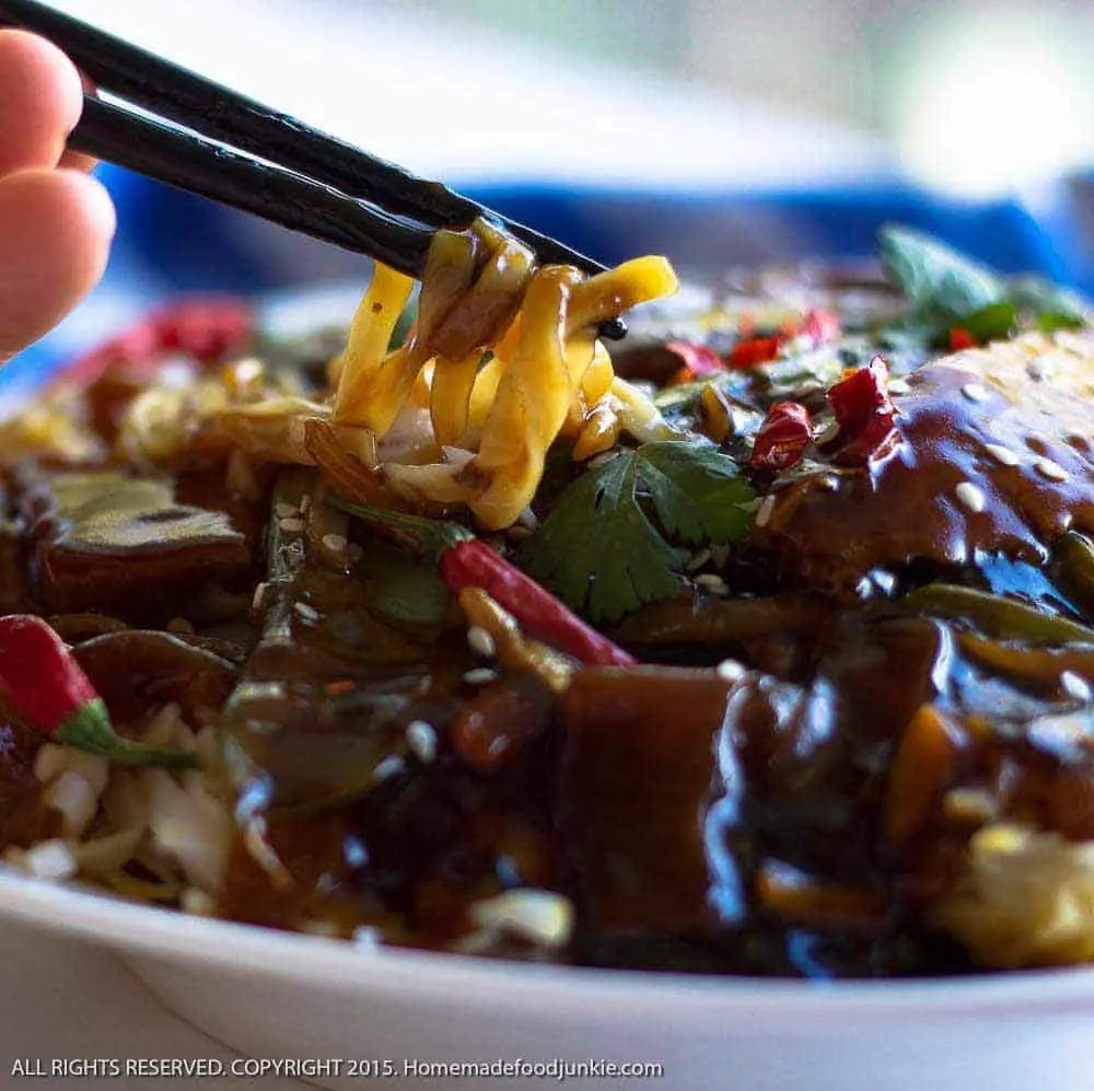 Sesame Beef Thai Noodle Dinner With Chopsticks Pulling Out The Noodles.