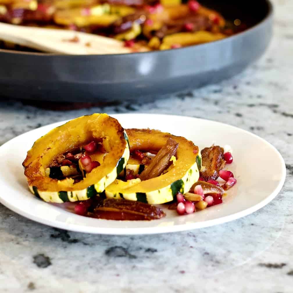 Delicata Squash Saute' On A White Plate With A Skillet Full Of This Recipe In The Background.