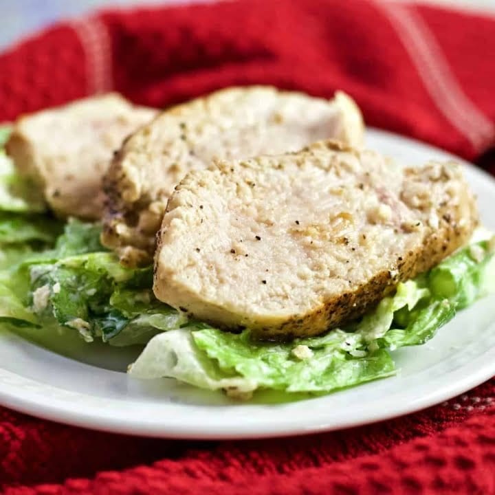 Pan Fried Chicken sliced on a salad bed on a white plate