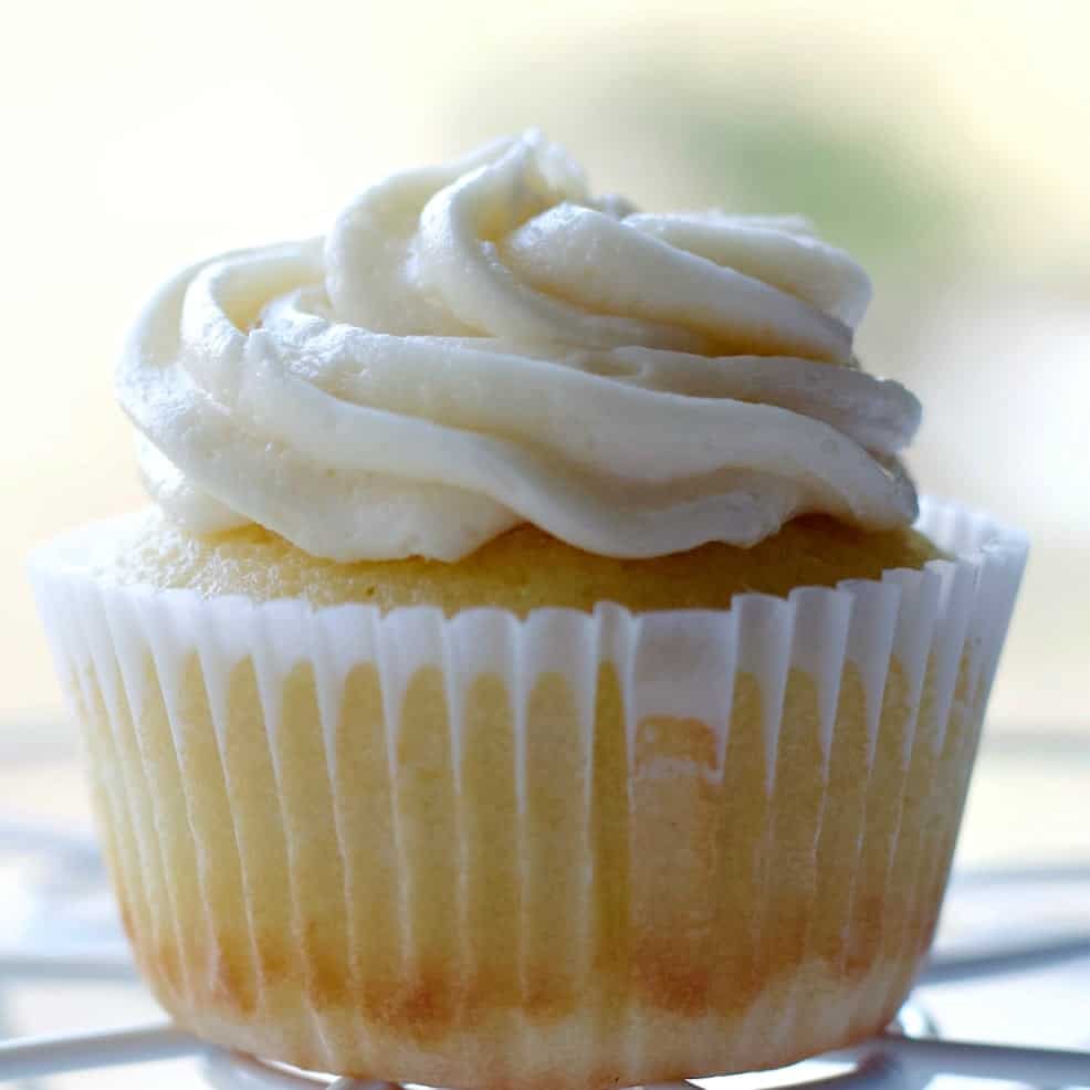 Vanilla cupcake with buttercream frosting in a white wrapper