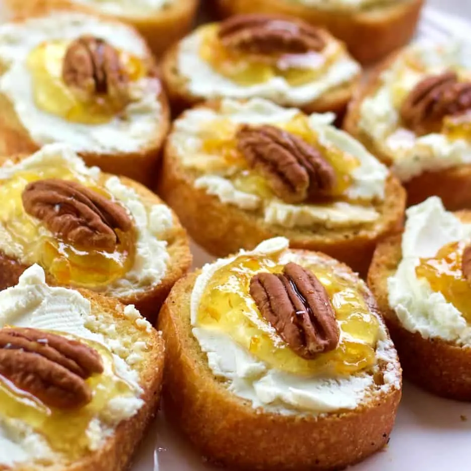 Several Crostini With Goat Cheese On A Plate