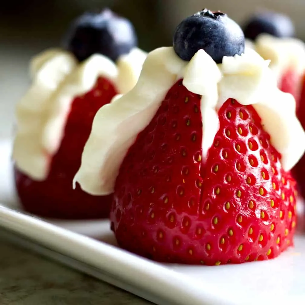 Goat Cheese Stuffed Dates With Prosciutto 4 Strawberry Filled With Sweet Cream Cheese And A Blueberry Topper.