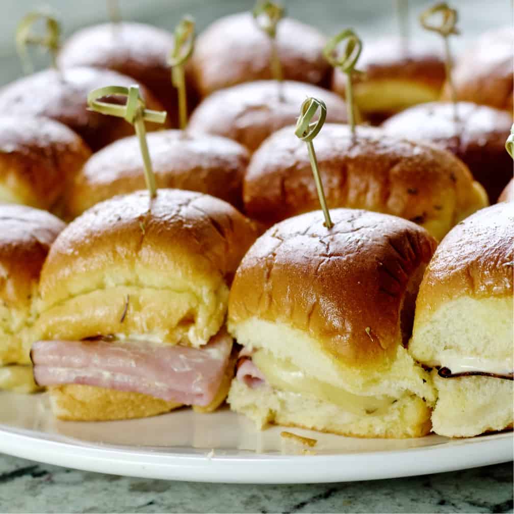 Baked Ham And Cheese Sliders Showing The Ham And Melted Cheese.