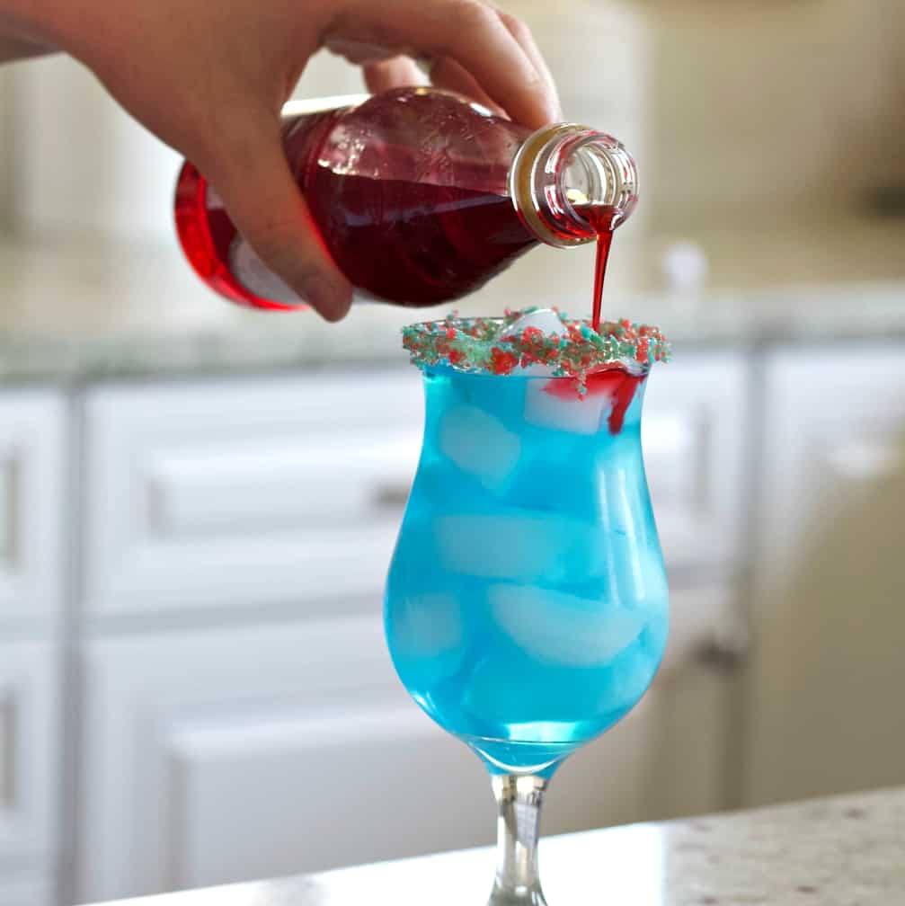 Pouring Grenadine Into The Blue Cocktail.