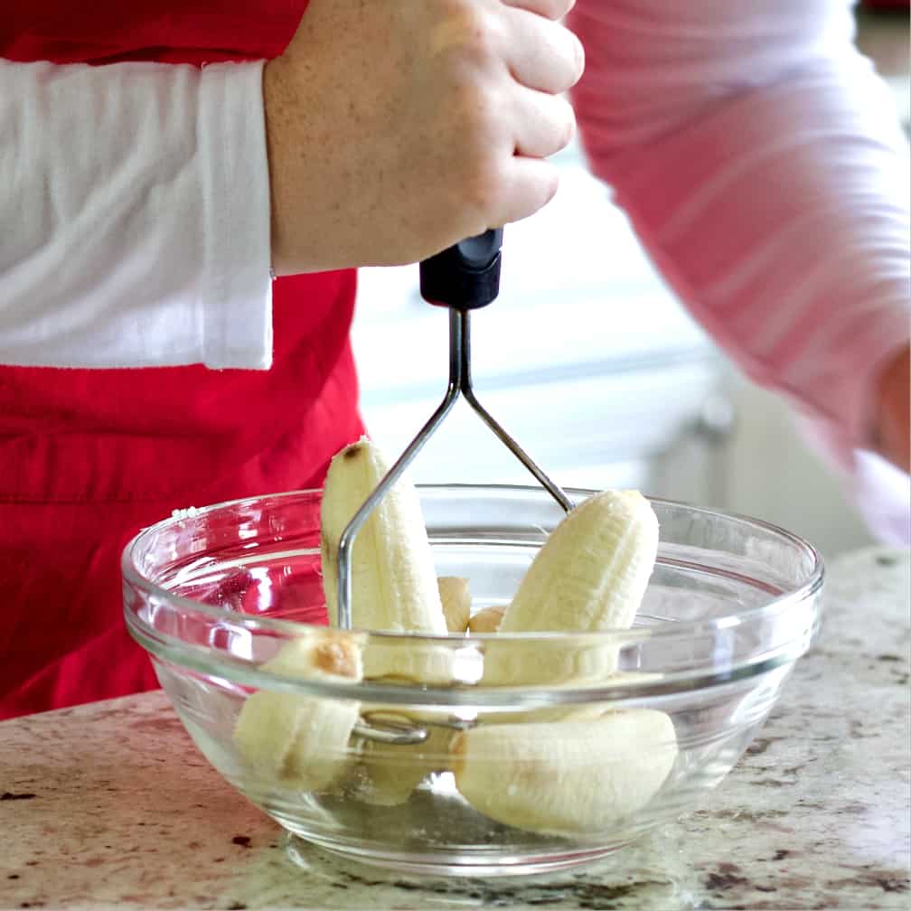 Mashing Bananas In A Clear Bowl-Banana Nut Muffin Recipe