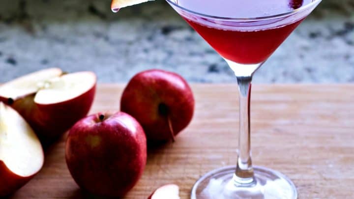 Apple drink with apples on a board.