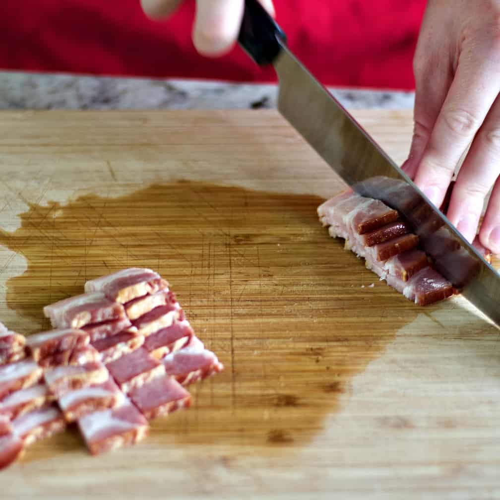 Cutting Bacon Into Bite Sized Pieces On A Cutting Board