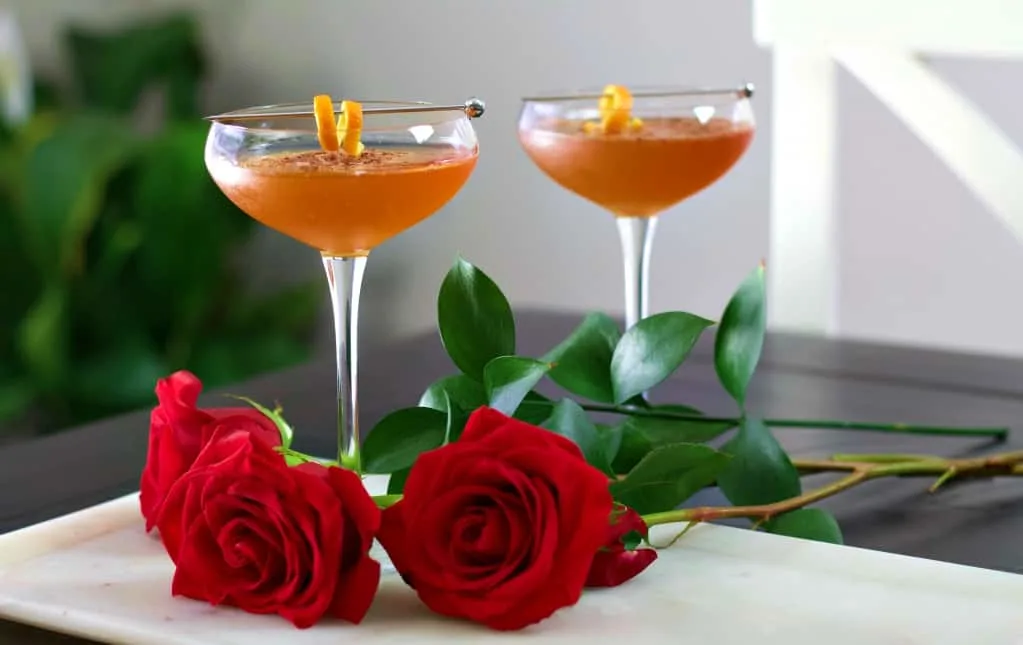 Two Chocolate Orange Margaritas On A White Tray With Red Roses.