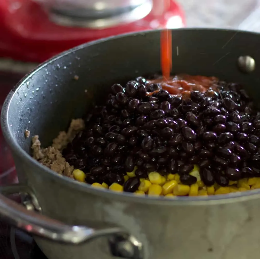 Pouring Tomato Sauce Into Hamburger Dinner