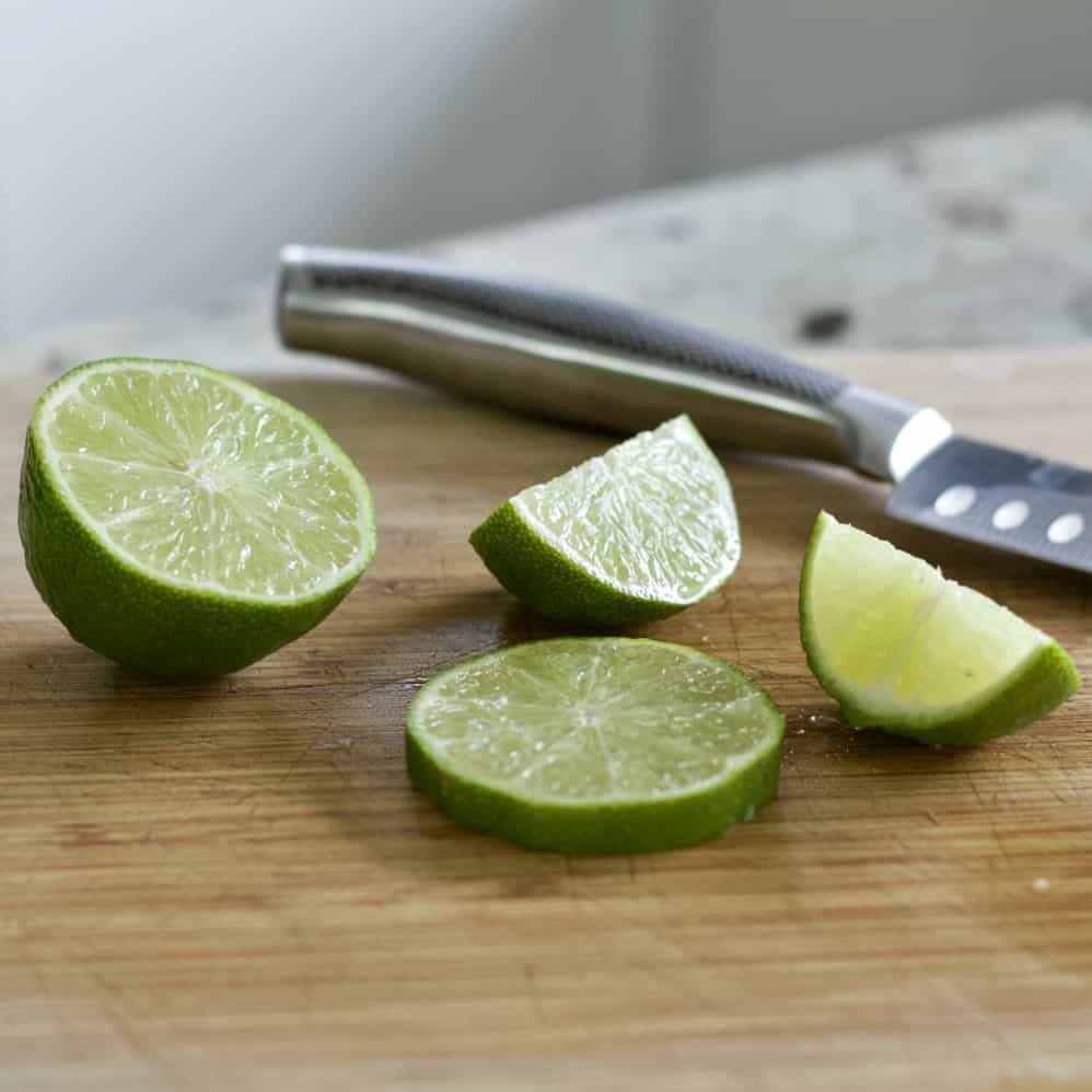 Lime Slices On Wooden Board
