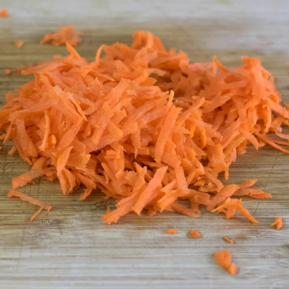 Grated Carrots On A Wooden Board