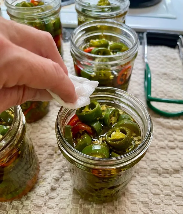 Wiping The Rim Of Filled Canning Jars