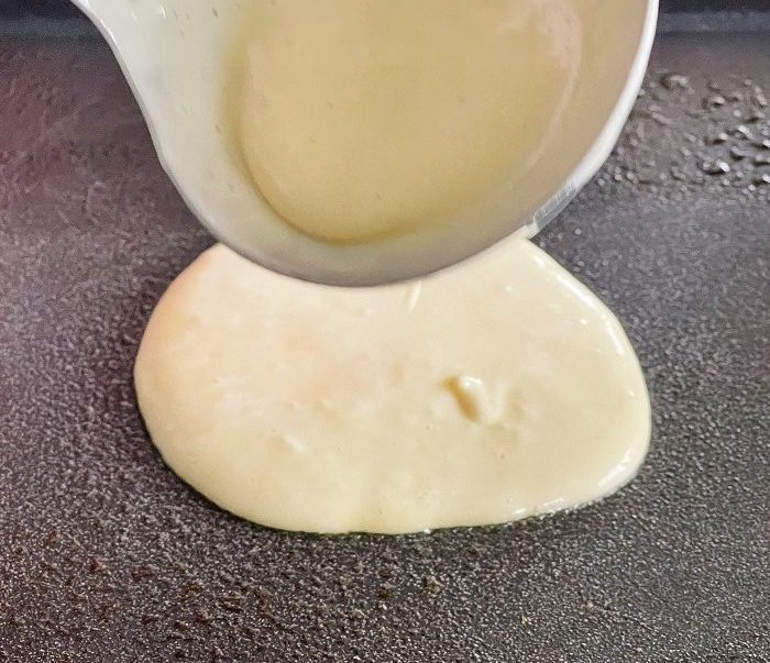 Pouring Out Sourdough Pancake Batter On A Hot Griddle