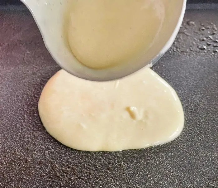 Pouring Out Sourdough Pancake Batter On A Hot Griddle
