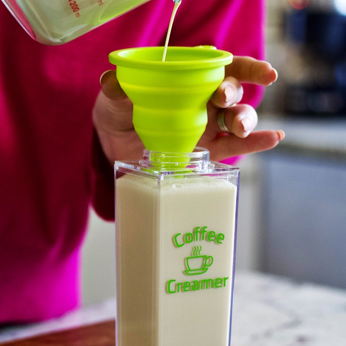 Pouring Homemade Coffee Creamer Into A Container For Storage Using A Funnel
