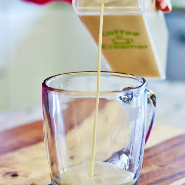 Pouring Homemade Coffee Creamer Into A Coffee Cup