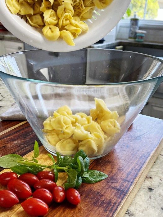 Twisted Caprese Tortellini Pasta Salad 4 Pouring Cooked Tortellini Into Salad Bowl