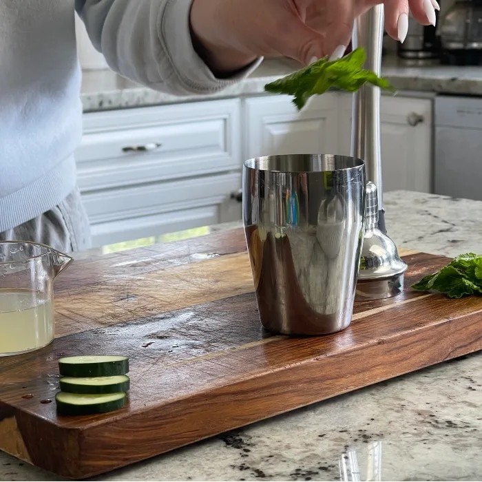 Adding Mint Leaves To Shaker-Cucumber Cooler