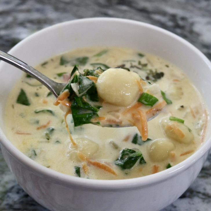Creamy bacon cheddar gnocchi soup in a white bowl