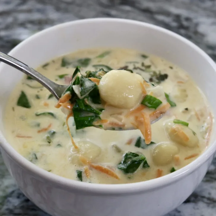 Creamy bacon cheddar gnocchi soup in a white bowl