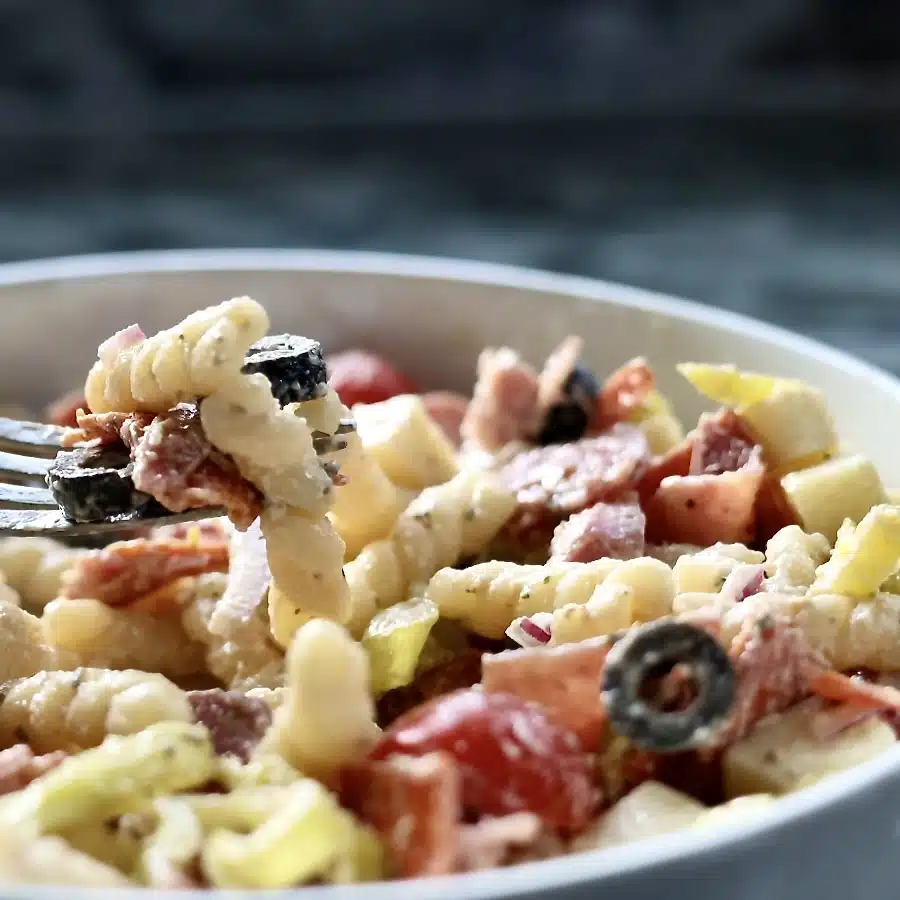 Creamy Italian Grinder Pasta Salad 2 Italian Grinder Pasta Salad. in a white bowl with a fork