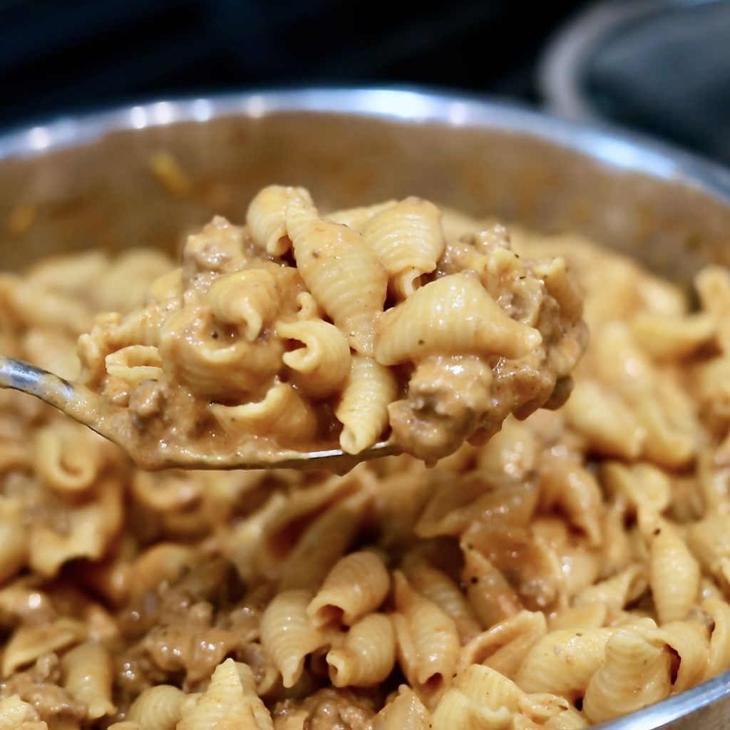 Weeknight Dinners: Easy Skillet, One-Pot, Sheet Pan + Slow Cooker Meals 6 cheesy Beef and Shells in a skillet on a large spoon.