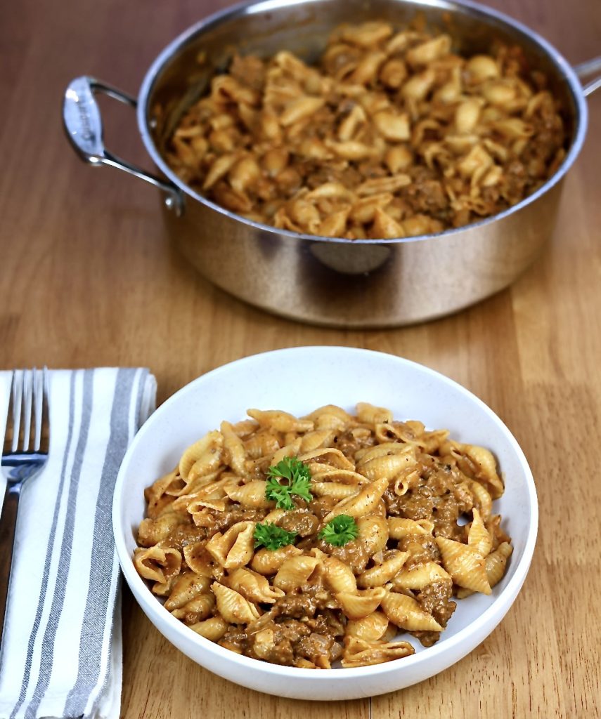 Ultimate Cheesy Beef and Shells Dinner 3 Cheesy Beef and Shells in a bowl with skillet in background.
