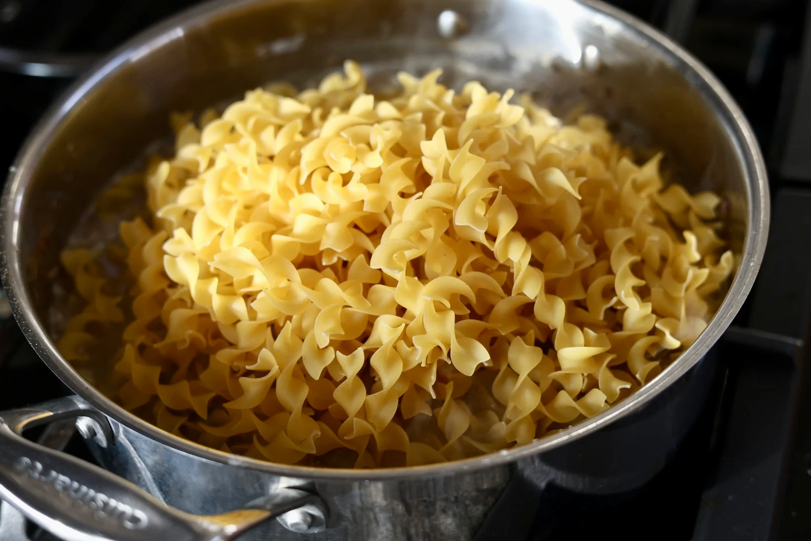Assembling Creamy Ground Beef Stroganoff With Egg Noodles In A Skillet