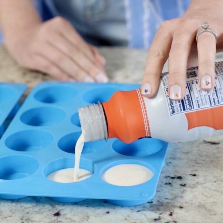 Pouring whipping cream into ice cube trays