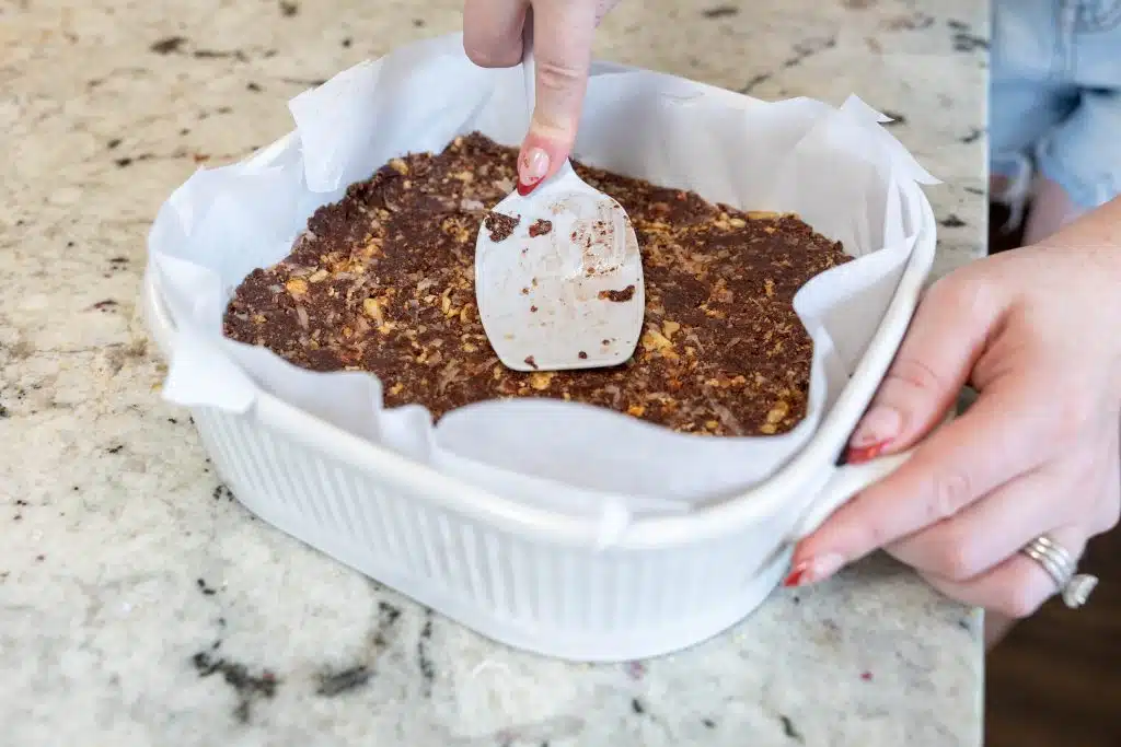 Pressing the crust layer for Nanaimo Bars