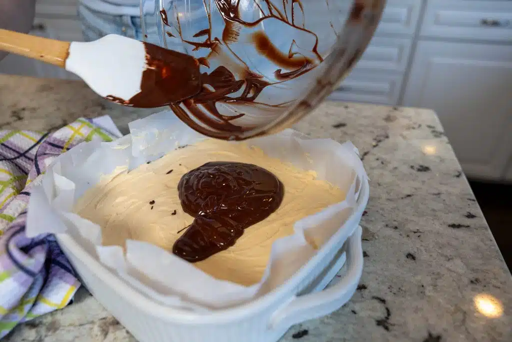 layering the chocolate on top of custard layer on nanaimo bars