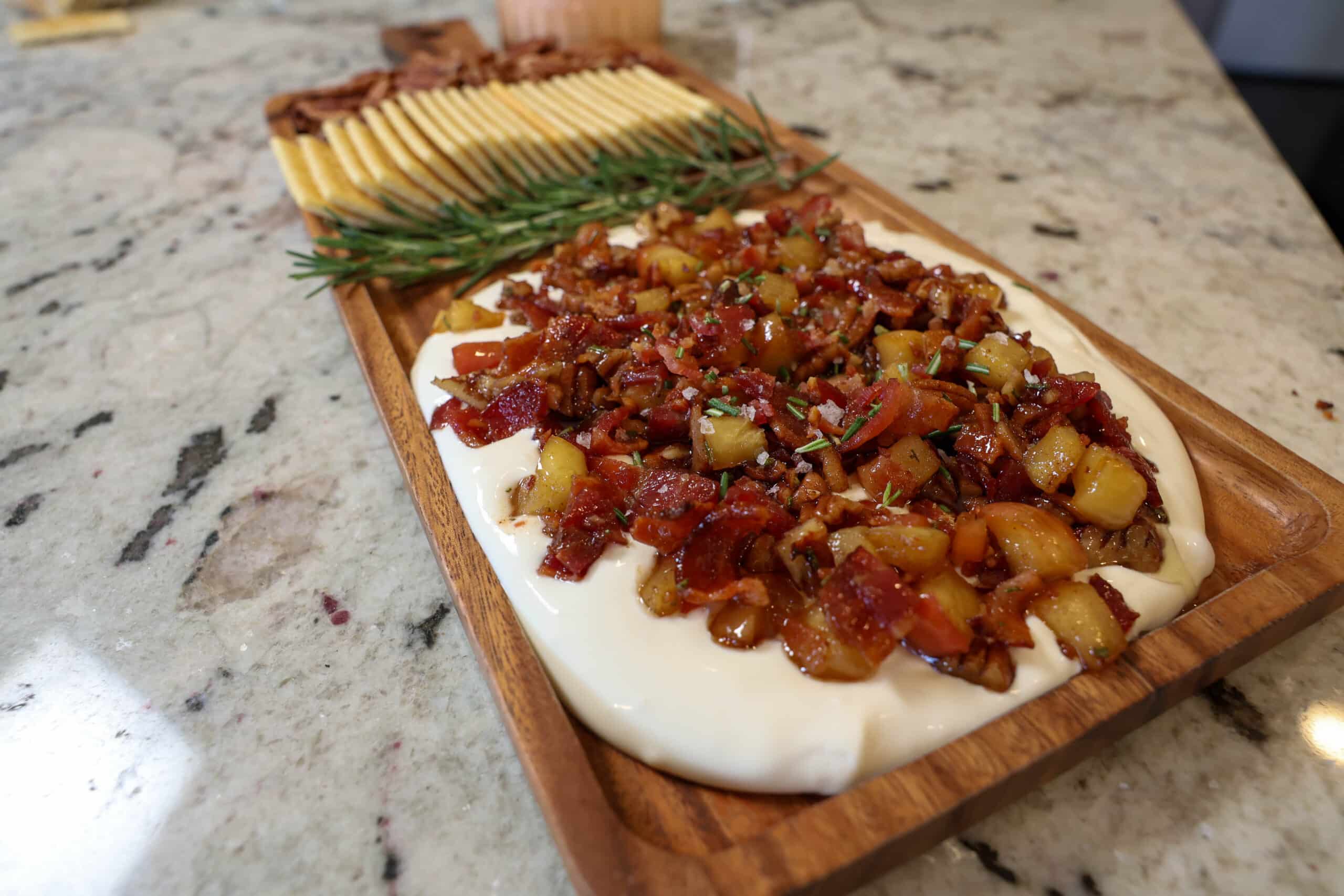 Plated appetizer Maple Bacon Whipped Goat Cheese with rosemary, crackers, and pecans