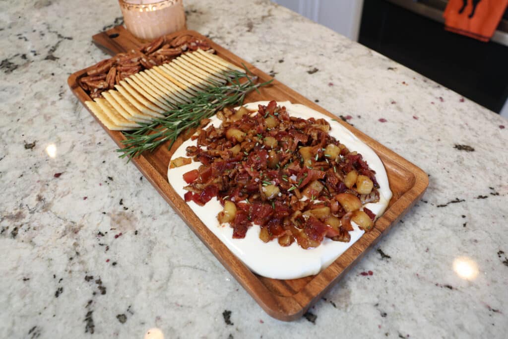 Brown Butter Maple Bacon Whipped Goat Cheese 9 A shot of the appetizer Maple Bacon Whipped Goat Cheese plated with crackers and pecans